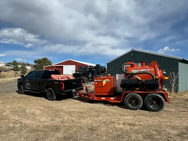  Biolein service pickup truck towing a Ditch Witch FX30 trailer-mounted vacuum excavation unit 