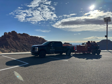  Biolein service truck towing a Ditch Witch vacuum trailer at a scenic overlook 