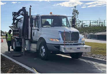 White Biolein hydro excavator truck performing vacuum excavation on a job site